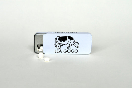 Metallic tin Lea Gogo with lactase tablets in front of the tin
